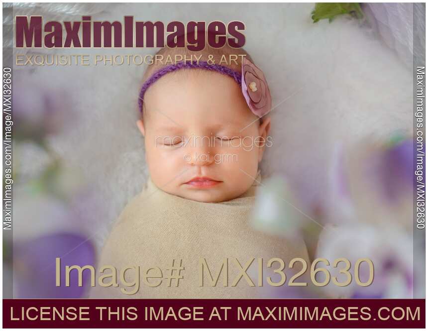 Newborn baby girl sleeping bundled-up closeup of face