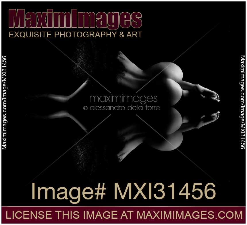 Nude figure of a woman back lying naked on reflective surface