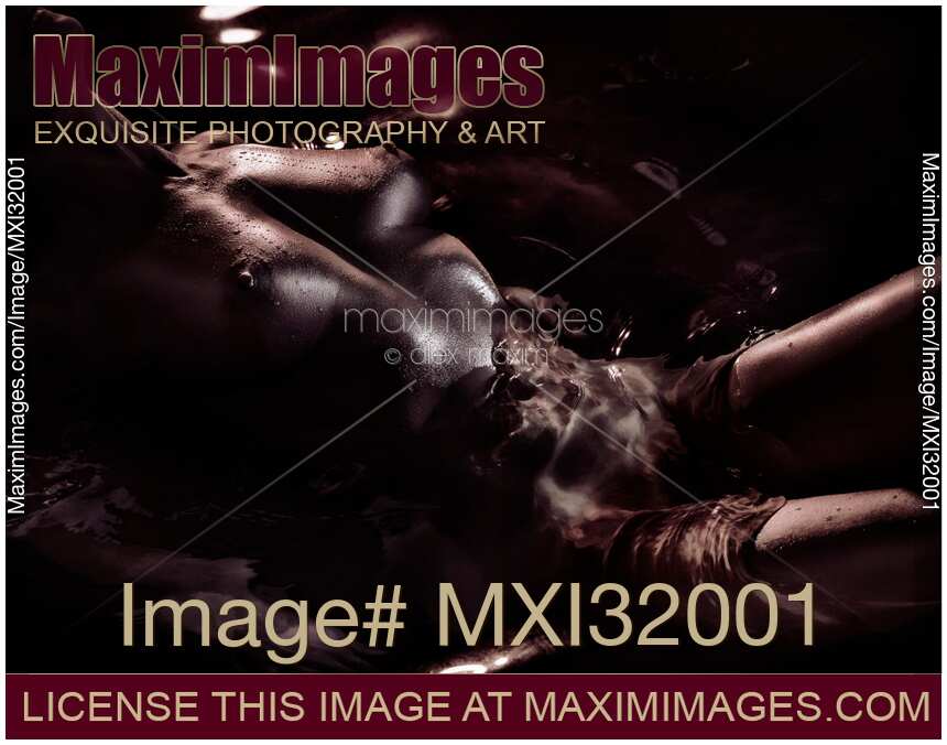 Nude woman body with sexy metallic skin lying in dark water