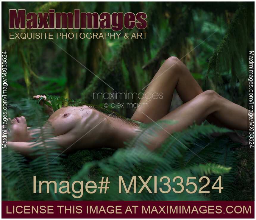 Nude woman lying down in a deep green mossy forest nature scenery