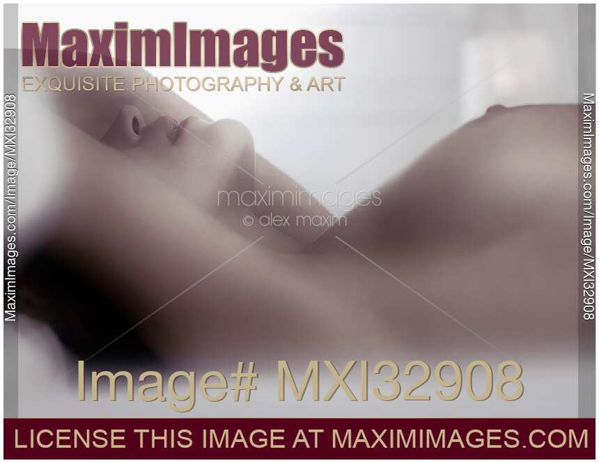 Nude woman lying in bed Sensual closeup of her breasts nipples and her lips
