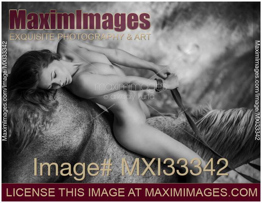Nude woman lying on a horse back in nature scenery Black and white erotic portrait