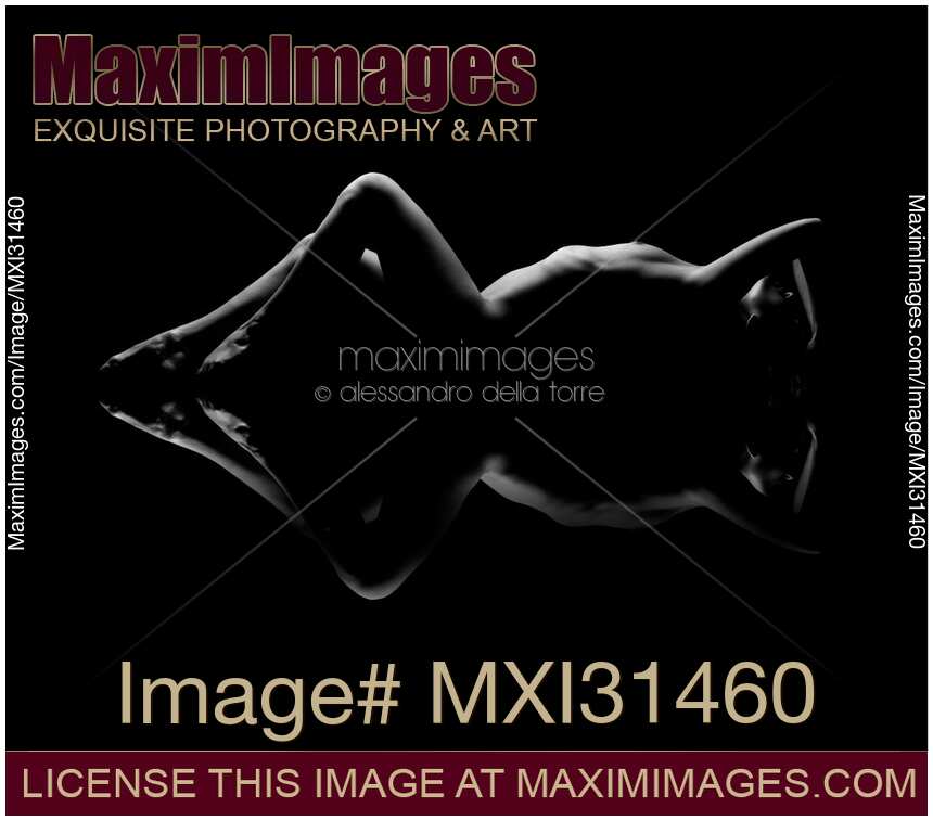 Nude woman lying on black background with a mirrored reflection