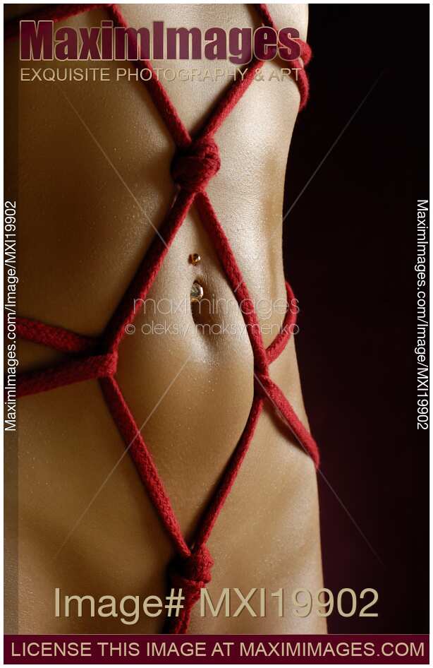Nude woman stomach with red rope bondage