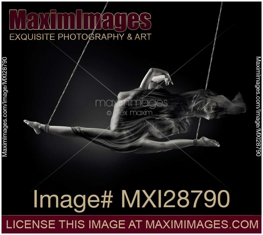 Nude woman swinging in splits in the air with bondage rope and flowing cloth around her naked body