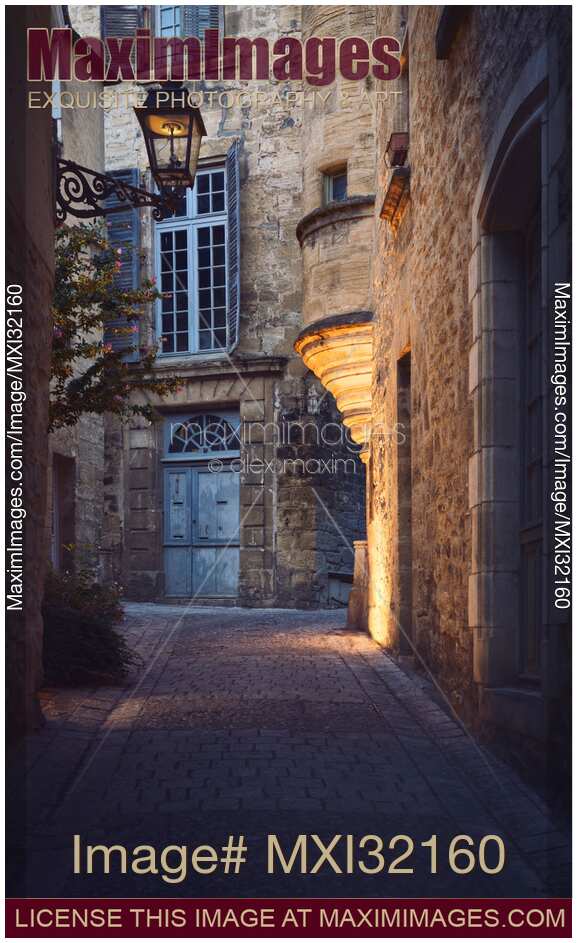 Old street with stone houses and a lantern in a historic town of Sarlat France