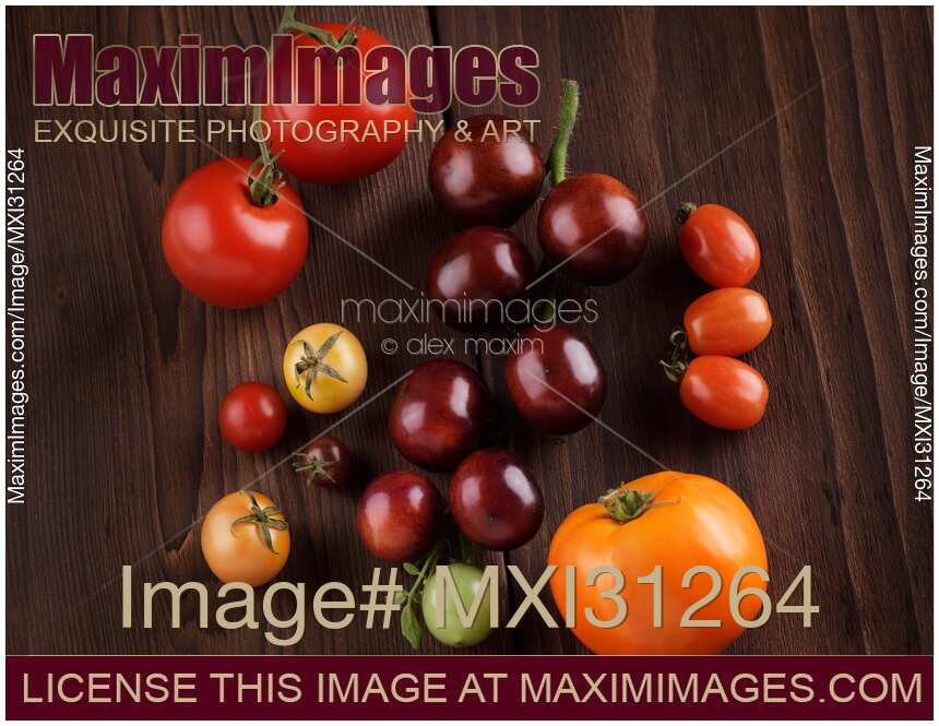 Organic heirloom tomatoes of a variety of sizes and colors food still life