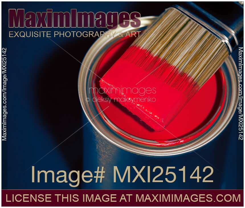 Paintbrush on can with red paint