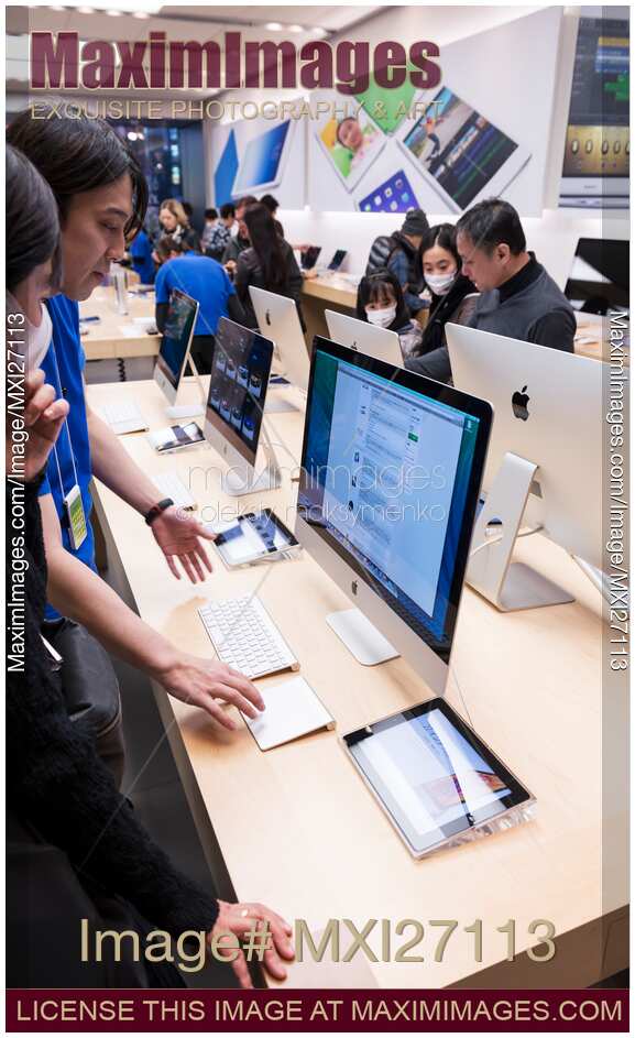 People at Apple store trying new computers