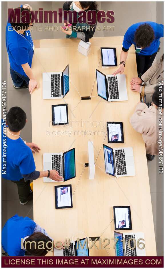 People at Apple store trying new MacBooks