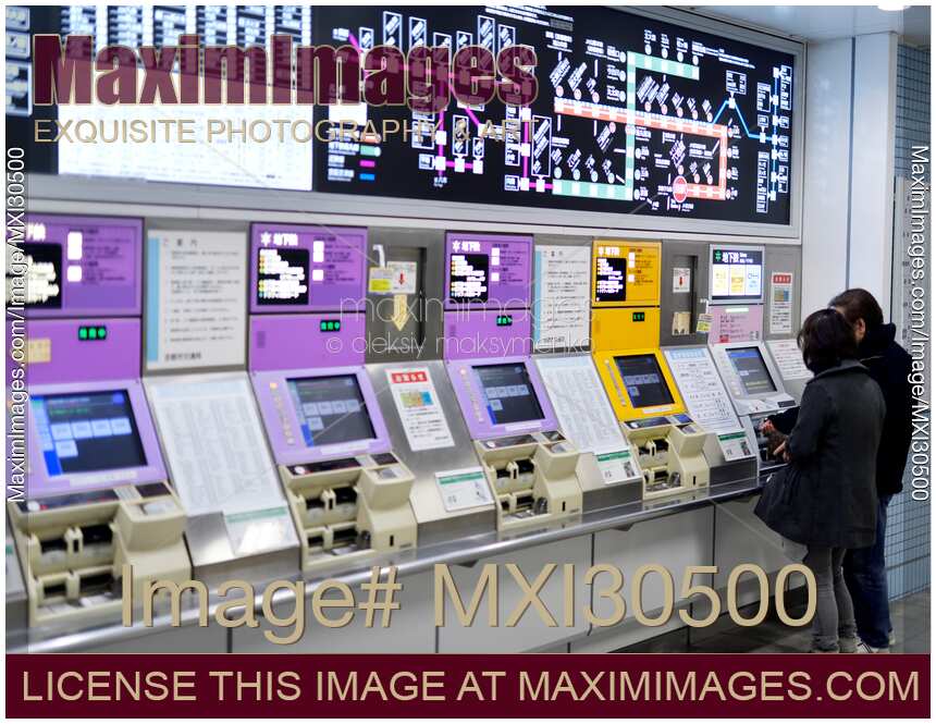 People buying tickets from a subway station ticket machine in Kyoto Japan