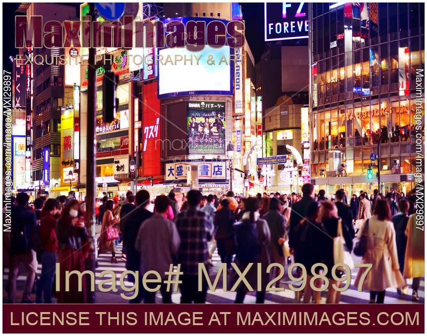 People crossing busy Shibuya interesection at night Shibuya station Tokyo Japan
