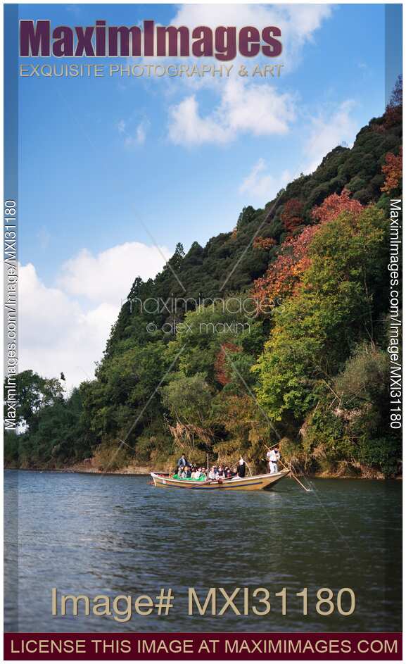 People enjoying a sightseeing ride on Hozugawa river boat cruise in Kameoka