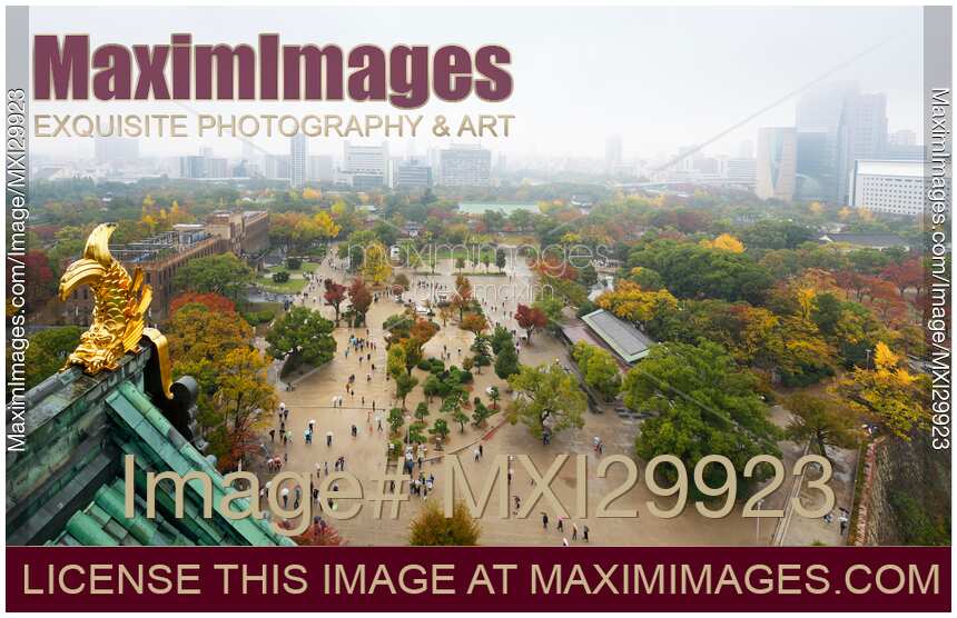 People in Osaka Castle Park site on misty rainy autumn day