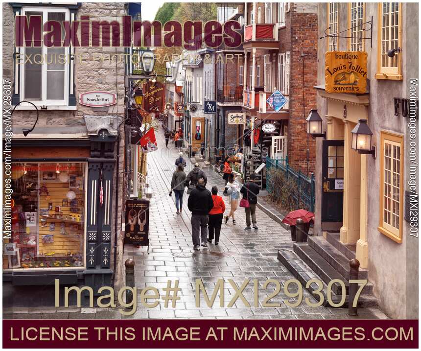 People in the rain on Rue du Petit Champlain historic street with its colorful stores of Old Quebec City
