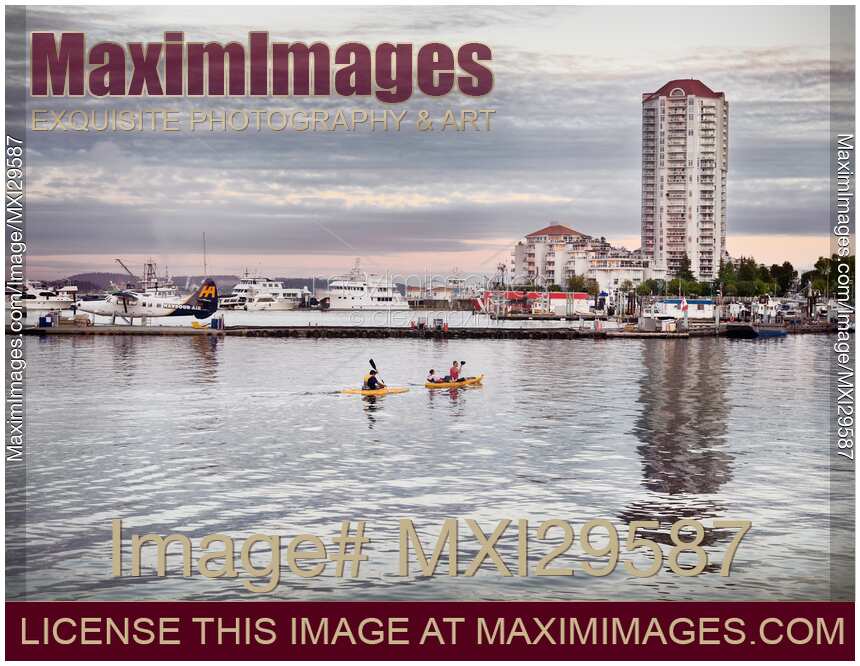People kayaking at sunset in Nanaimo city waterfront Vancouver Island
