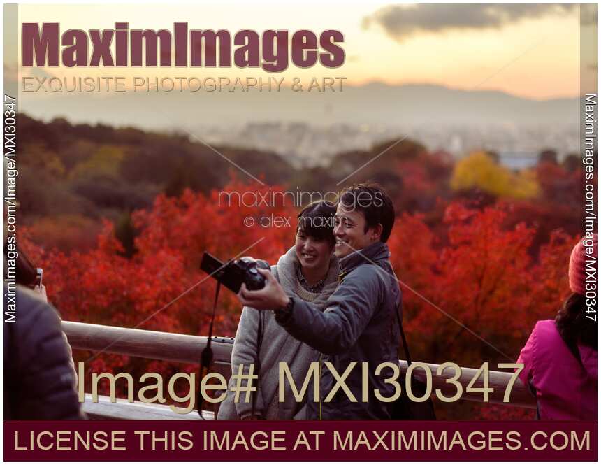 People taking a picture of themselves at Kiyomizu-dera in autumn sunset Kyoto Japan
