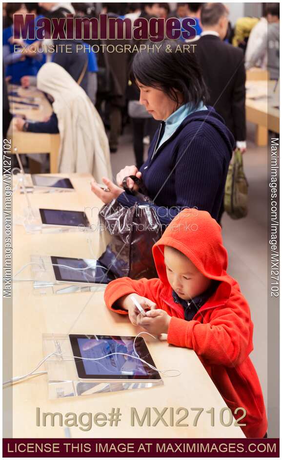 People trying new iPhone at Apple store in Japan