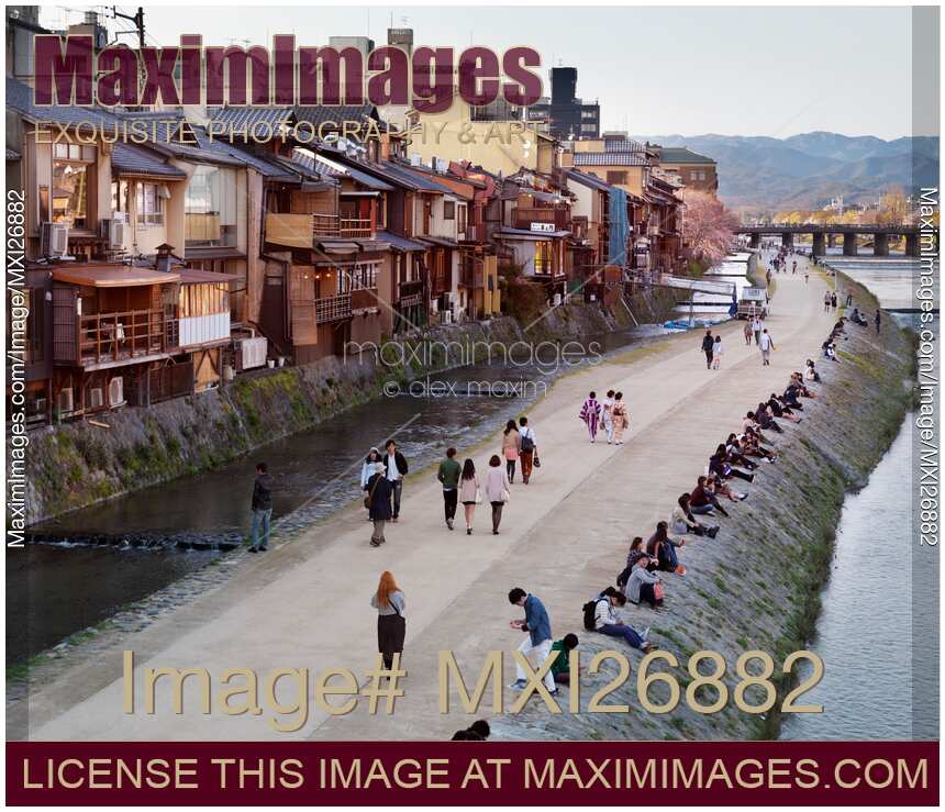 People walking along Kamo River in Kyoto