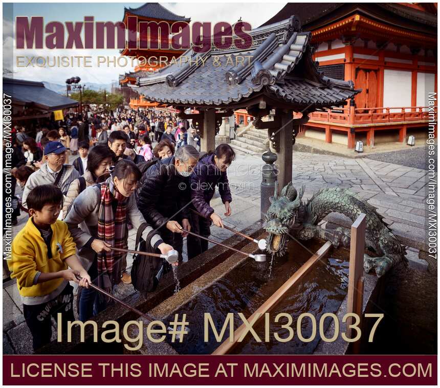 People washing hands at chozubachi basin for cleansing ritual at Kiyomizu-dera temple Kyoto