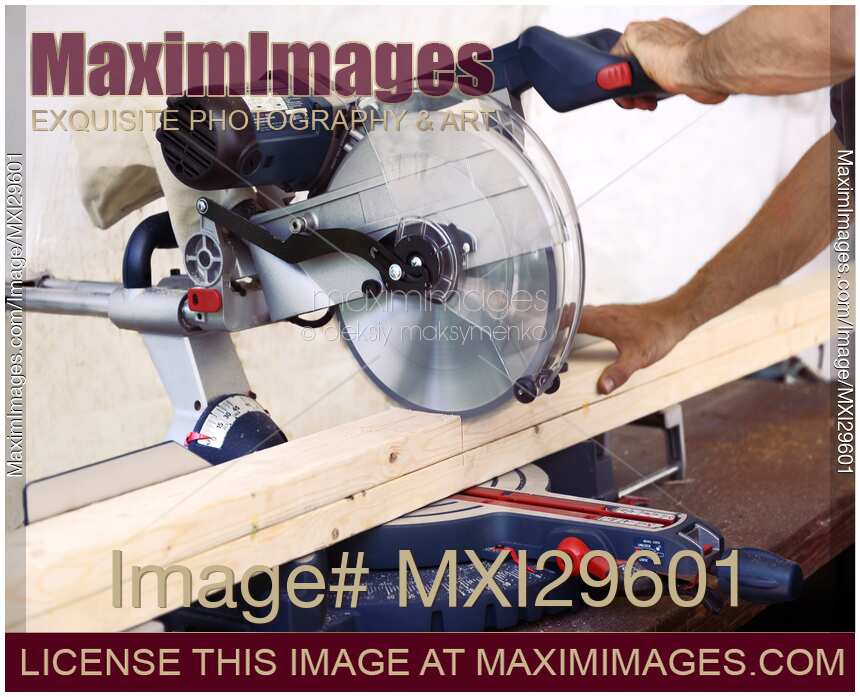 Photo of Person cutting wood lumber with miter saw Stock Image MXI29601