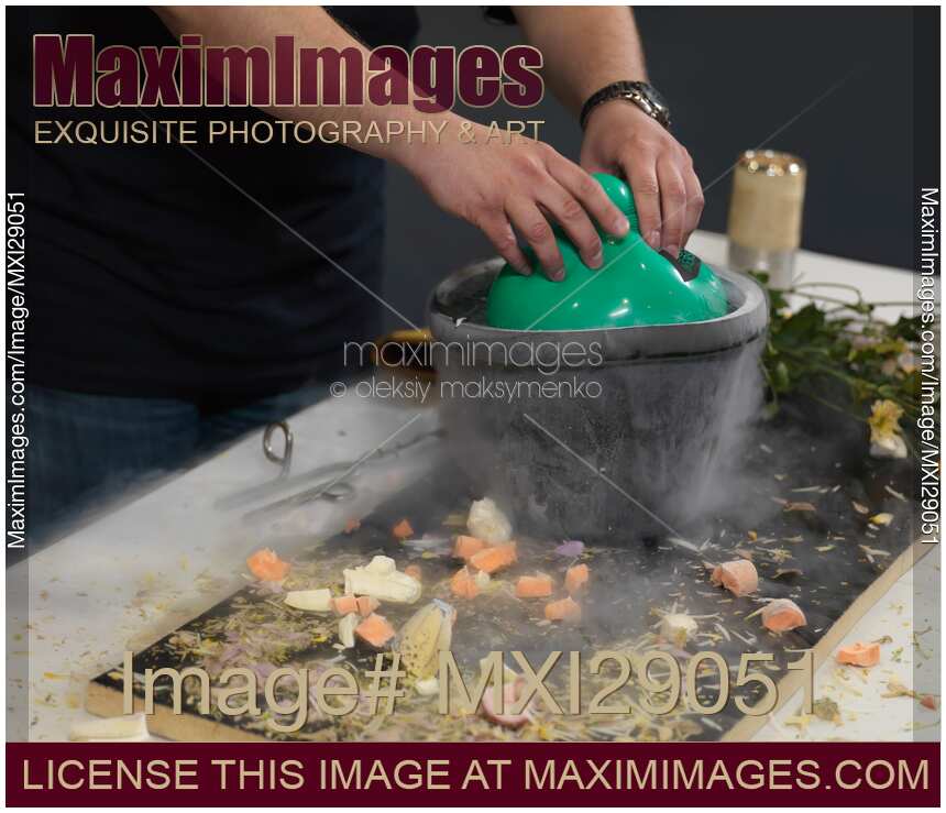 Person Submerging an Air Balloon into Liquid Nitrogen