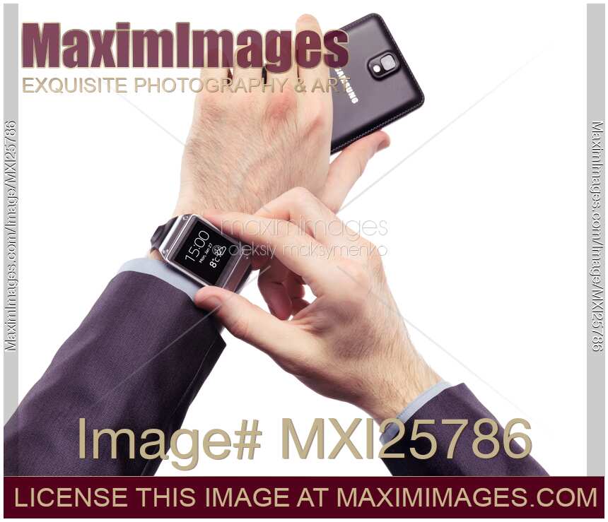 Person with Samsung smartphone and Galaxy Gear watch
