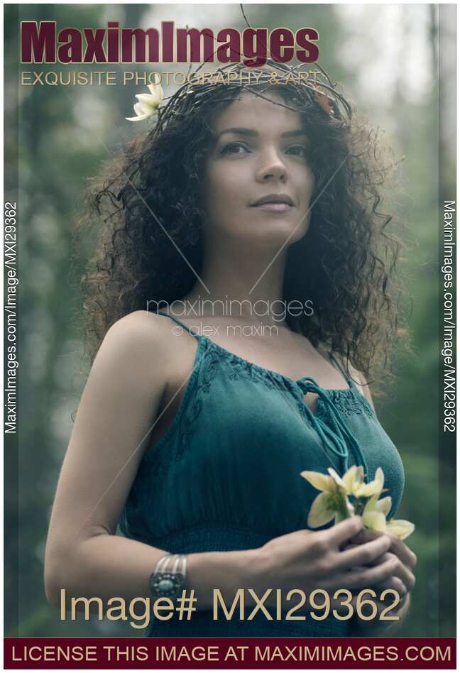 Portrait of a beautiful woman with a wreath on her head and a flower in her hands