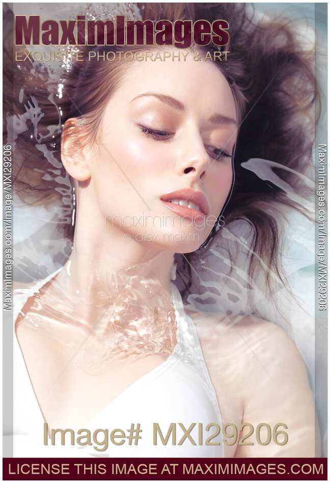 Portrait of a beautiful young woman with fresh clean face lying in water
