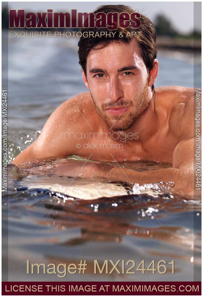 Portrait of a man with surfboard in water