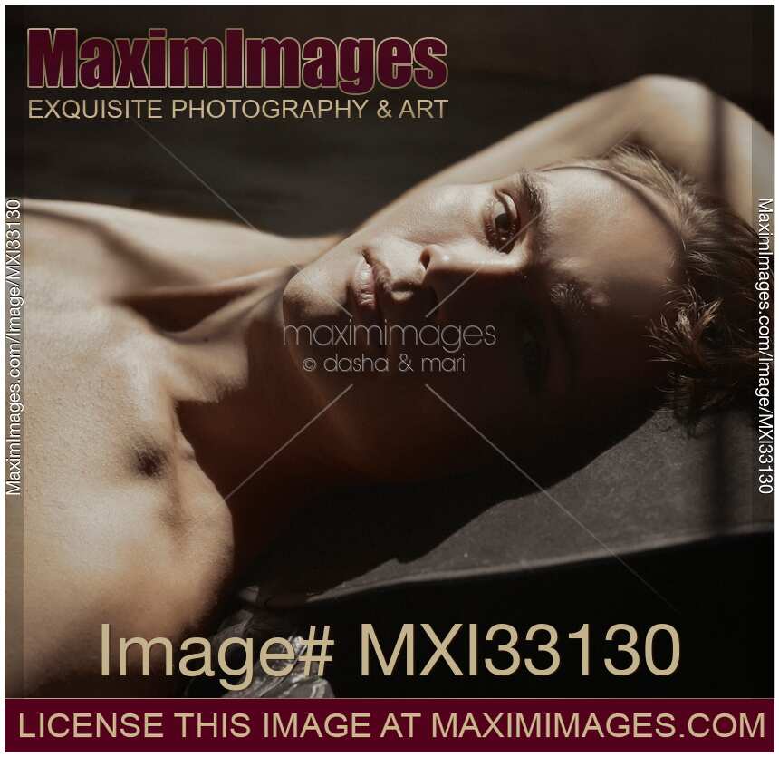 Portrait of a sexy handsome man face with short blond hair, bare torso and expressive contemplative gaze