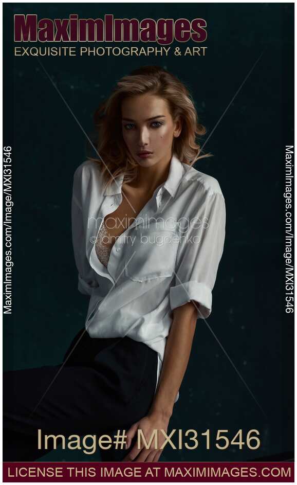 Portrait of a woman with an expressive look in an unbuttoned white shirt