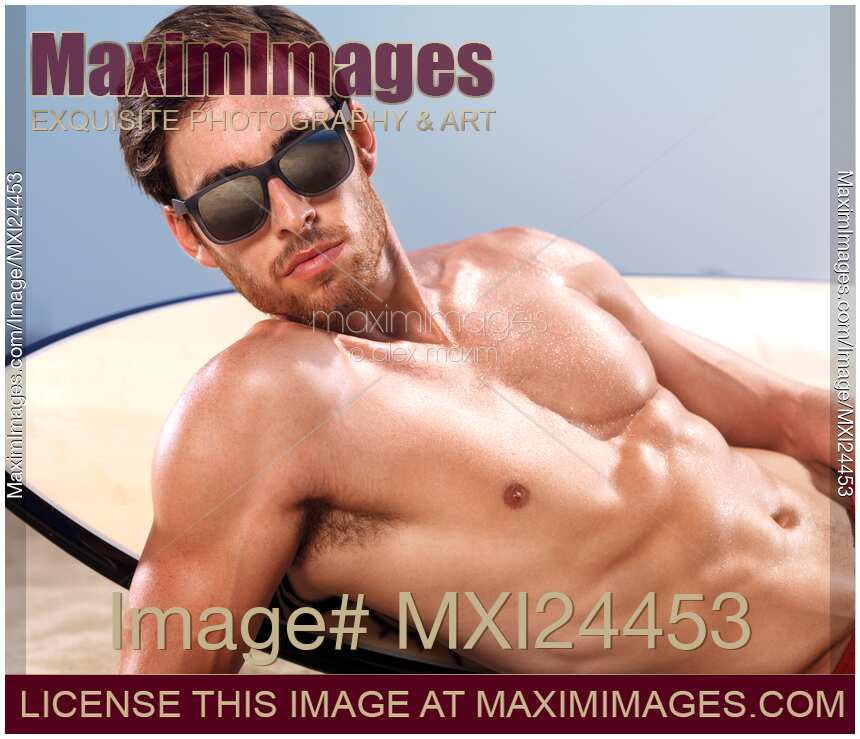 Portrait of a young man with surfboard wearing sunshades
