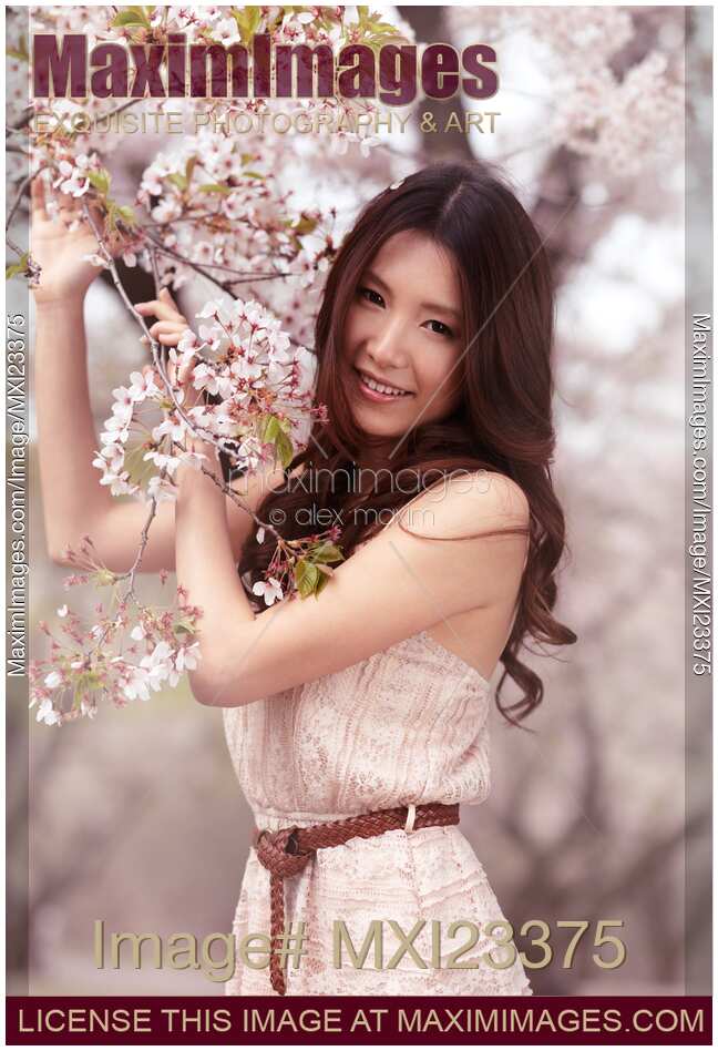 Portrait of a Young Smiling Woman Standing at a Cherry Tree