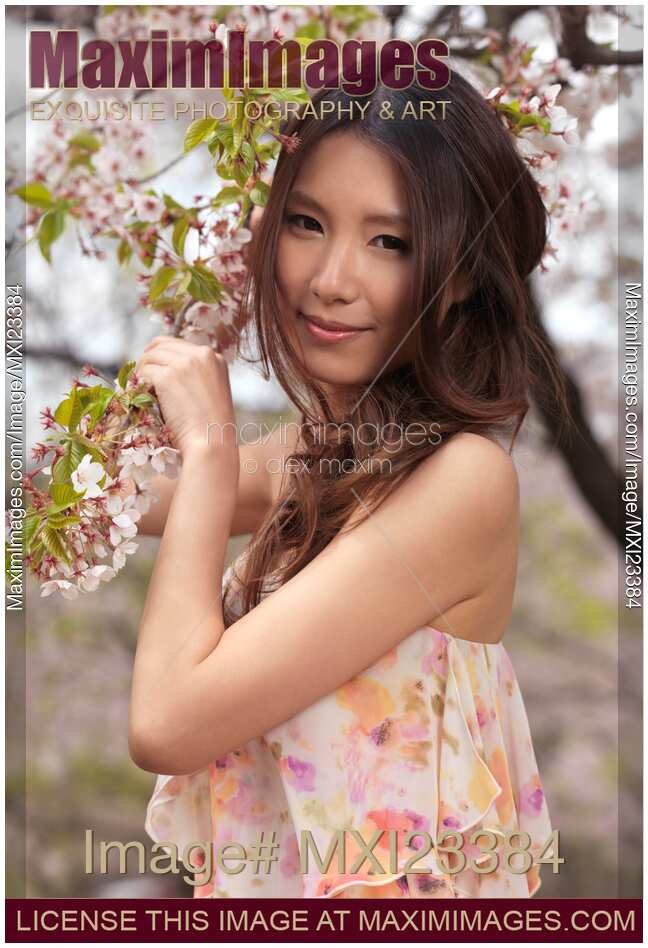 Portrait of a Young Smiling Woman Standing at a Cherry Tree