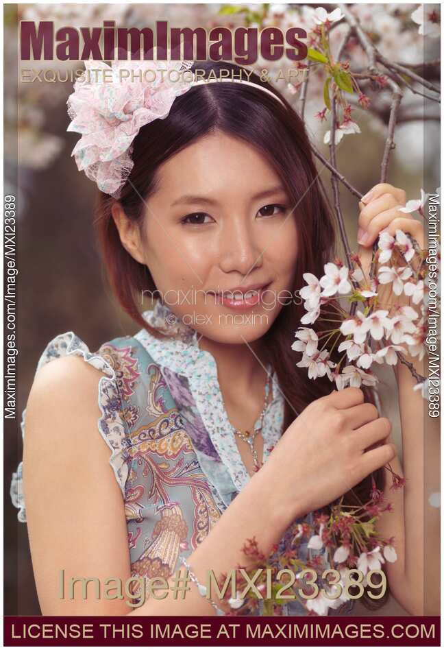Portrait of a Young Smiling Woman Standing at a Cherry Tree