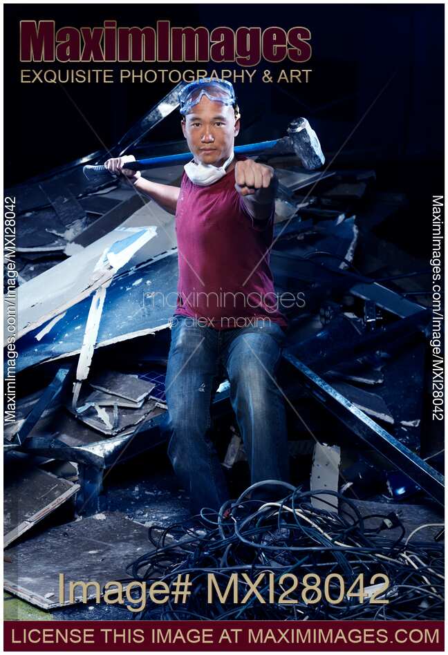 Portrait of man in Kung Fu stance with sledgehammer at demolition work