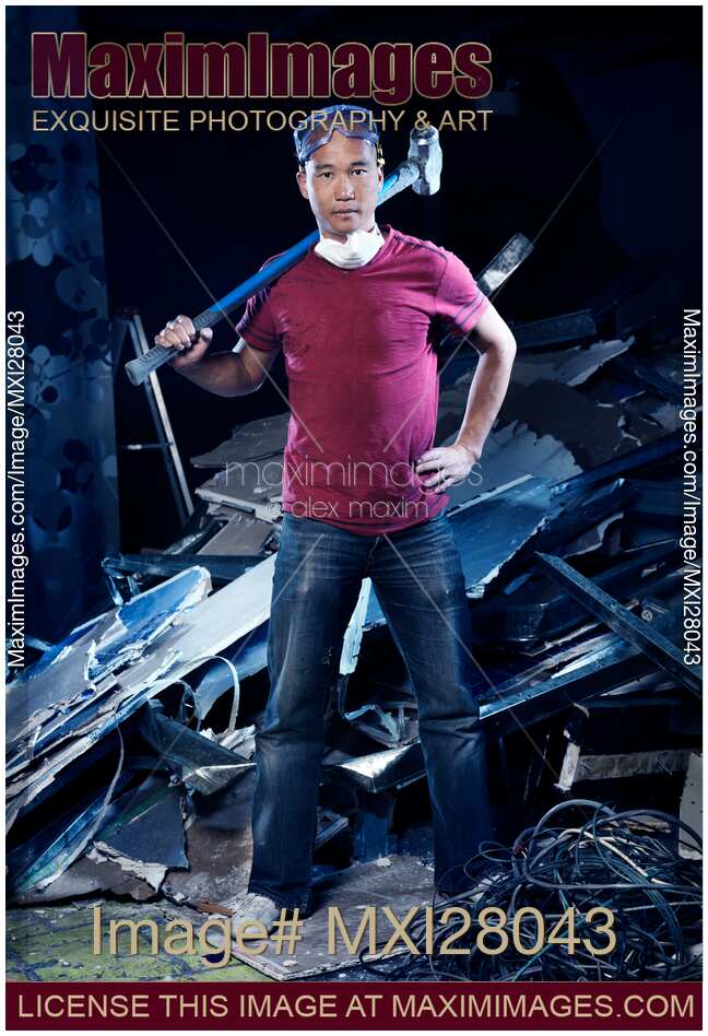 Portrait of man with sledgehammer at renovation site