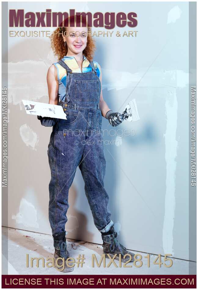 Portrait of woman construction worker patching up drywall