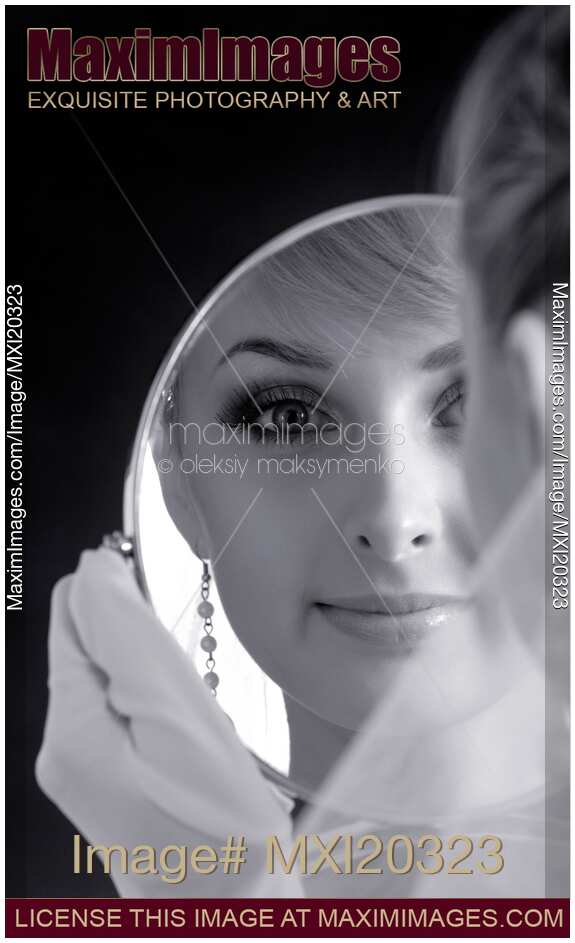 Portrait of young bride looking in a mirror