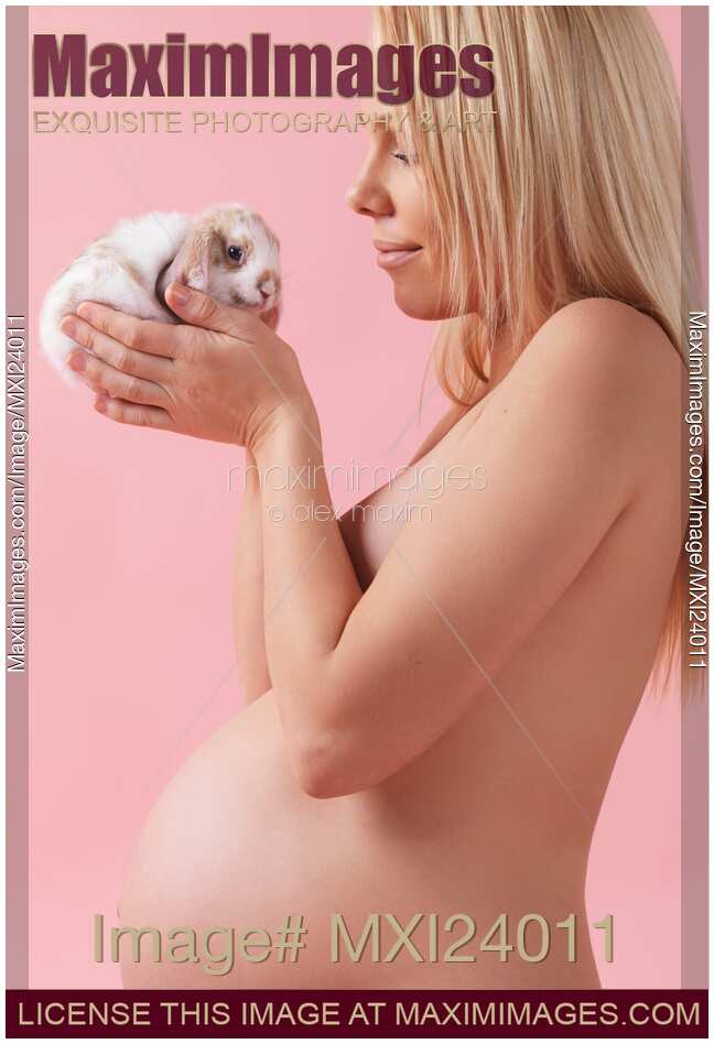 Pregant young woman holding a bunny in her hands