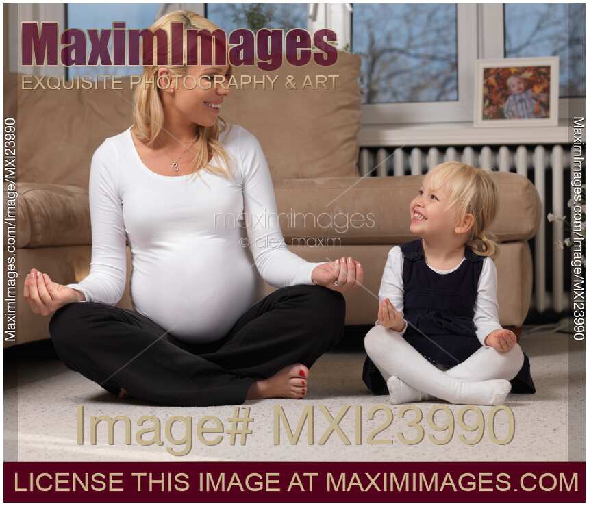 Pregnant mother and little daughter doing yoga