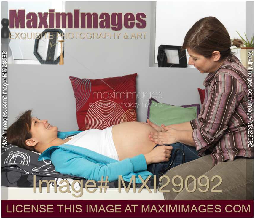 Pregnant Woman Being Inspected by a Midwife