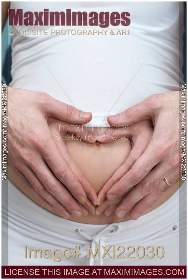 Pregnant Woman with Hands Making Heart Shape on Her Belly