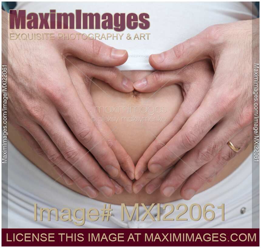 Pregnant Woman with Hands Making Heart Shape on Her Belly
