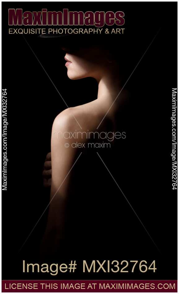 Profile portrait of a woman in black hat with dramatic shadows covering her face and body