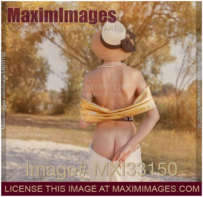 Provocative sensual rear view of a half naked woman in vintage hat lowering her skirt revealing her buttocks