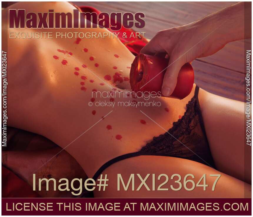Red candle dripping over sexy half-nude woman body. Hot wax sensual foreplay.