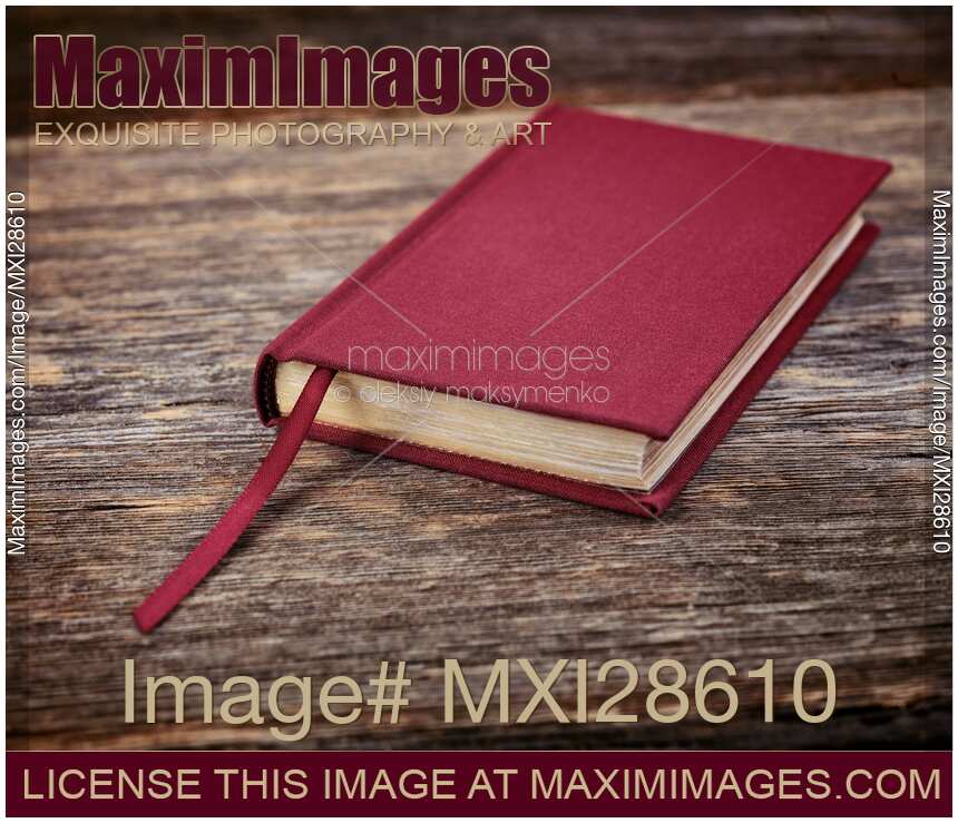 Red hardcover book on wooden background