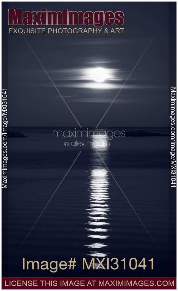 Rise of the Full Harvest Moon above Pacific ocean black and white